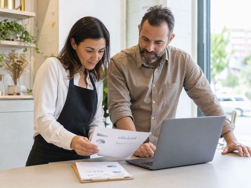 Dos propietarios revisan un informe de SEO local en su negocio de Jerez.